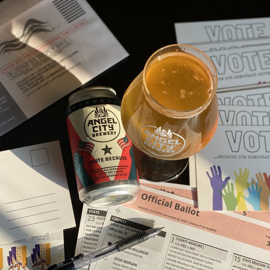 Can of I Vote Because next to glass of the same beer, on a table surrounded by ballots & voter info