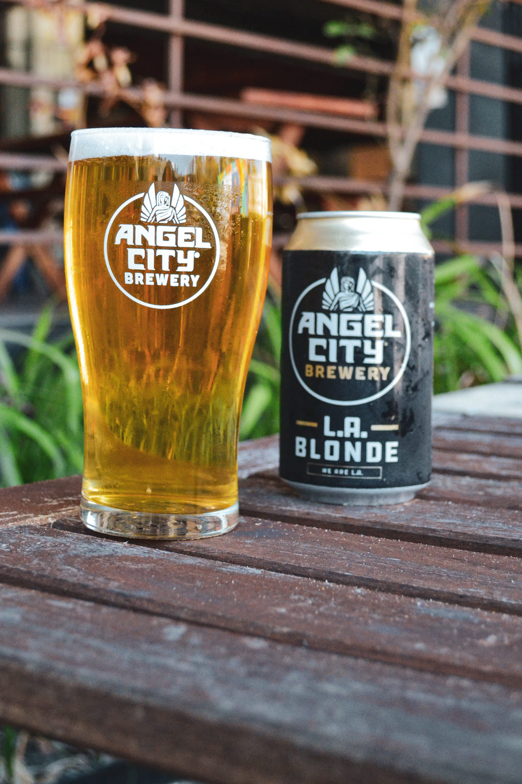 Pint glass filled with L.A. Blonde next to can of L.A. Blonde on table