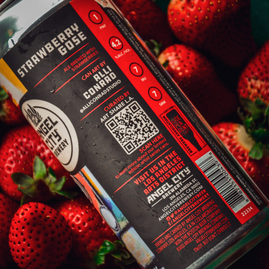 A can of Angel City Brewing's Strawberry Gose laying on a bed of fresh strawberries. Can art by local artist Alli Conrad, in partnership with ArtShare LA