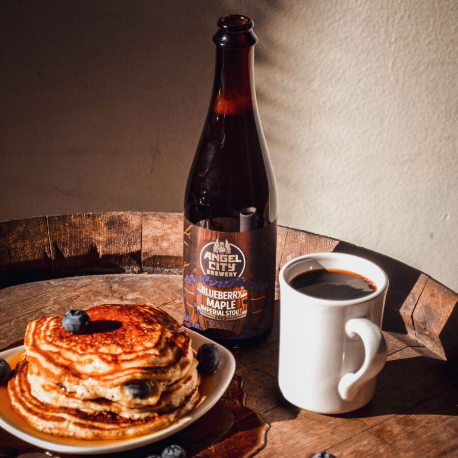 500ml bottle of Blueberry Maple Imperial Stout next to some flapjacks and coffee